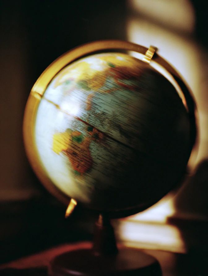 A desk globe spinning in warm window light