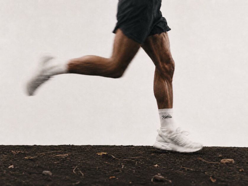 A runner mid-stride from the waist down, with Kettle written on a white sock