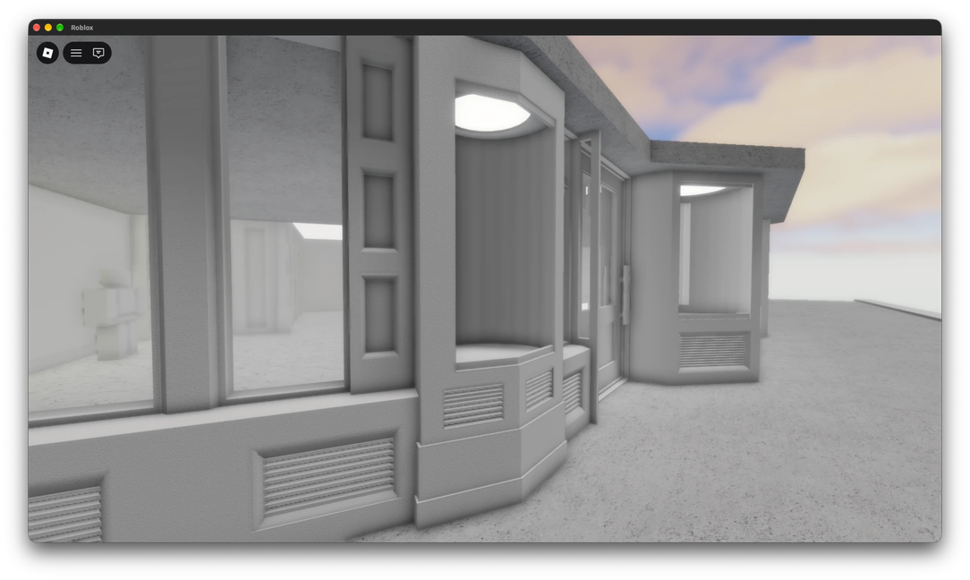 An untextured grey shopfront with bay windows, vents and recessed lights